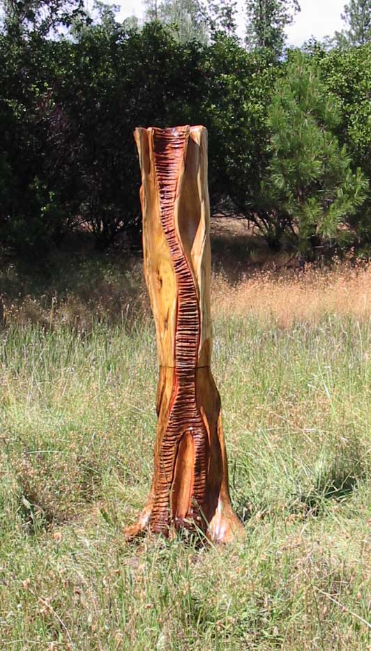 A 6 foot Carved Abstract Wood Sculpture, Carved from Pacific Willow with Tung oil finish and red painted accents in some of the carved grooves